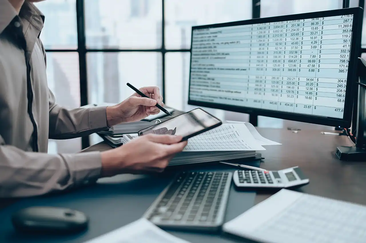 Analyst reconciling utility charges using spreadsheets and billing records